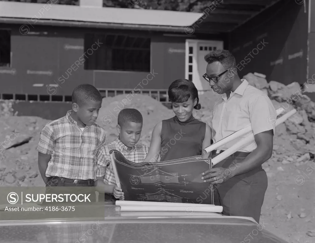 1960S African-American Family Looking At Blueprints New House Construction