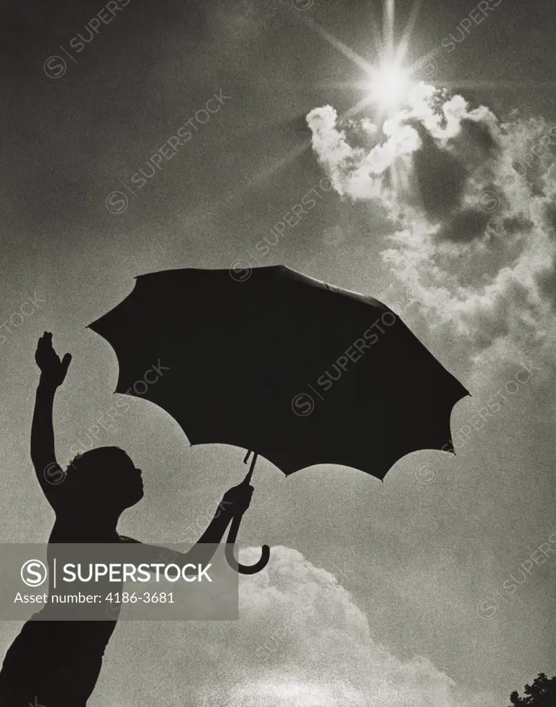 1960S Child Silhouette Standing With Umbrella Under Bright Sun