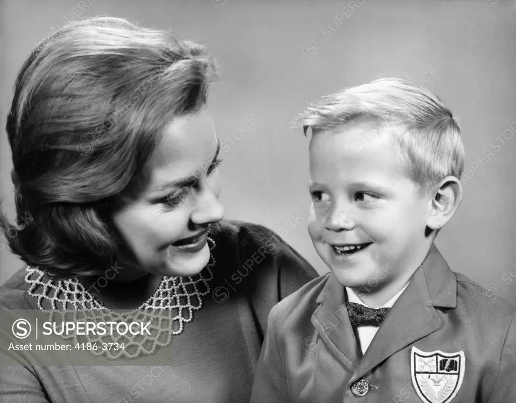 1960S Portrait Mother With Arm Around Son Dressed In School Uniform With Bow Tie & Emblem Crest On Jacket Mom Pearl Lace Collar