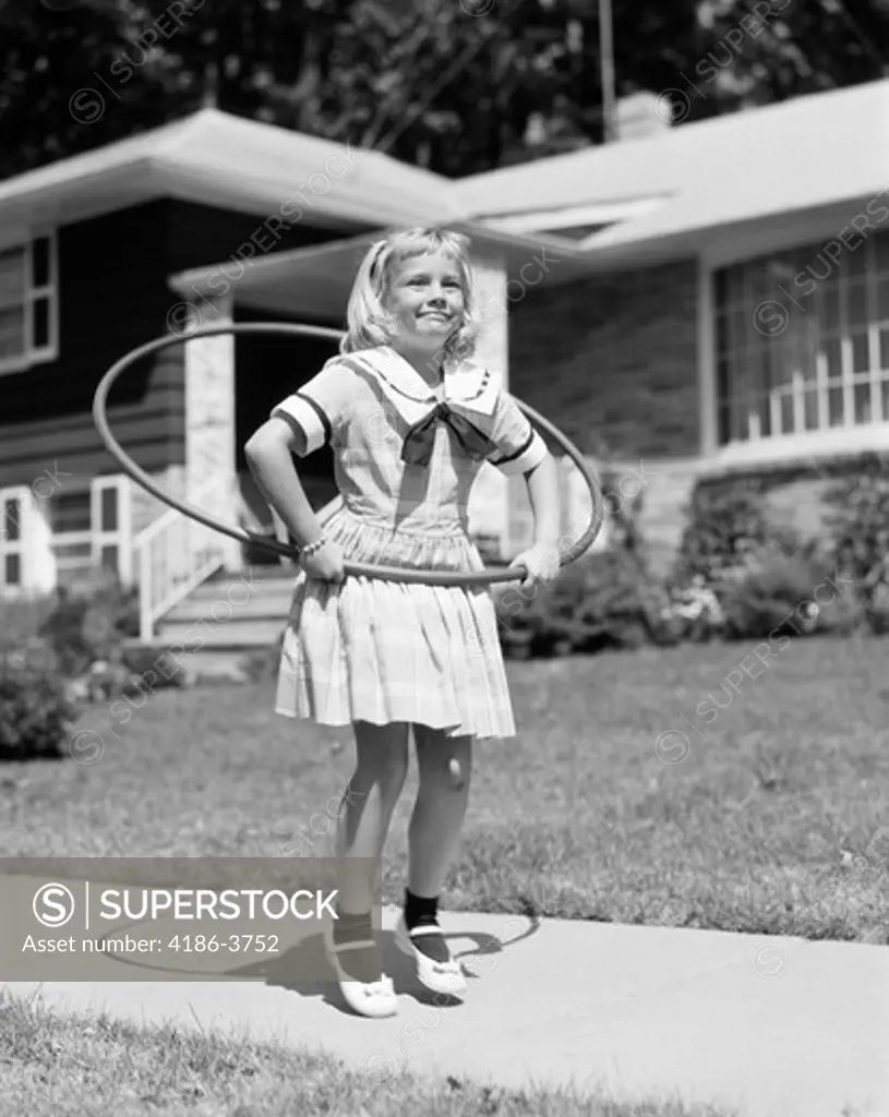 1950S Girl In Dress On Suburban Sidewalk Using The Hula Hoop