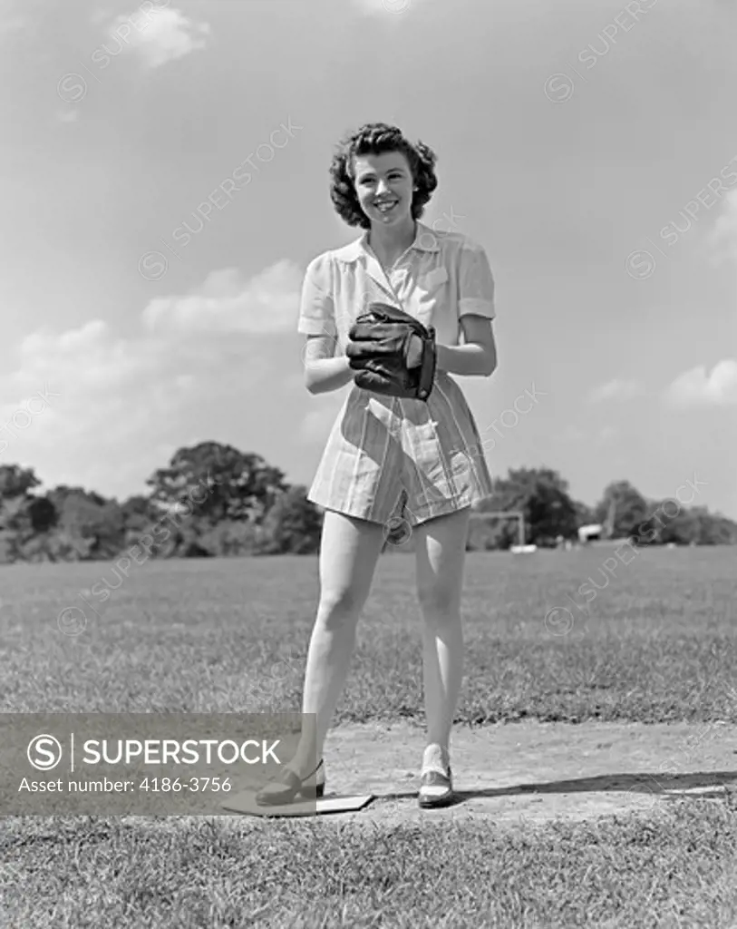 1940S Smiling Teen Girl Wearing Shorts Standing On Pitchers Mound Soft Ball Glove Mitt On Her Hand Softball