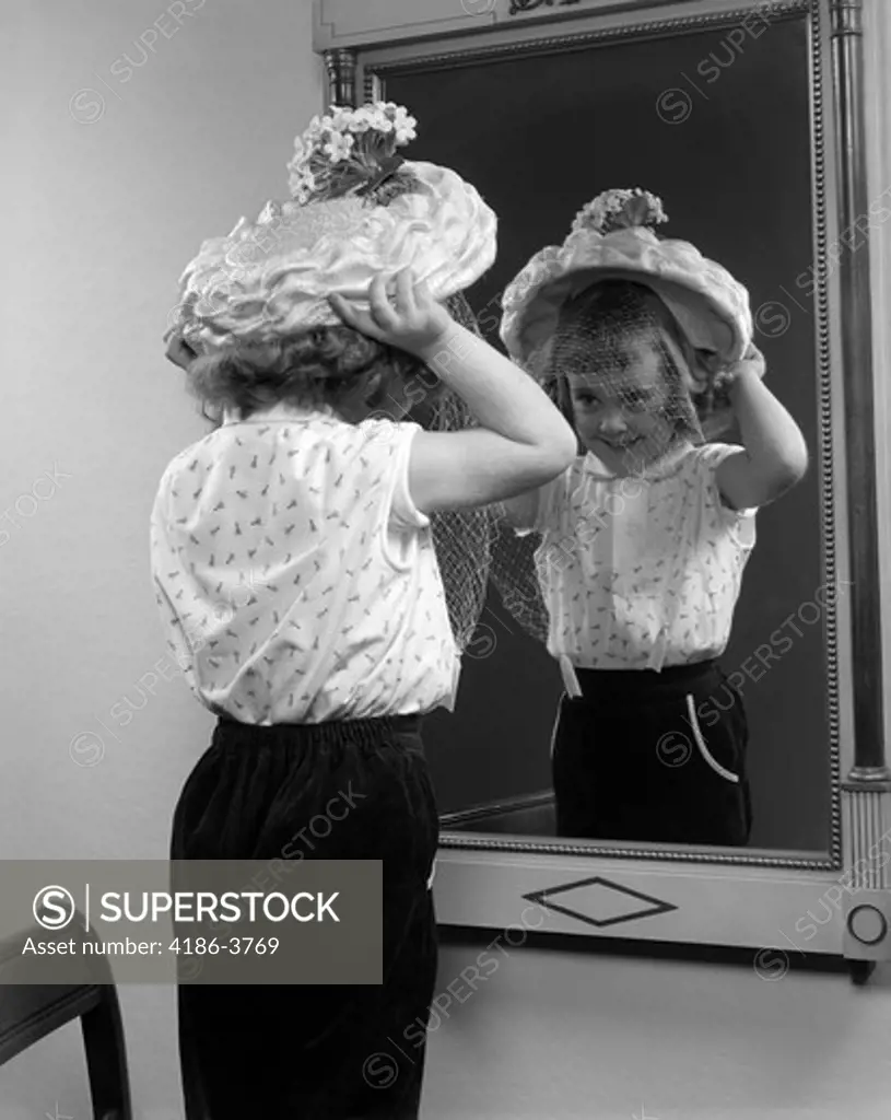 1950S Little Girl Trying On Hat Looking Into Mirror Reflection