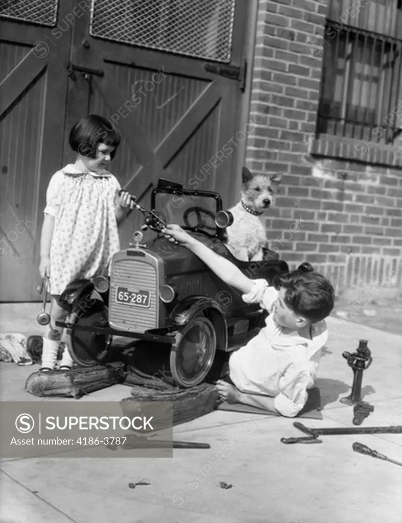 1930S Two Children Boy Girl And Dog Fixing Toy Automobile