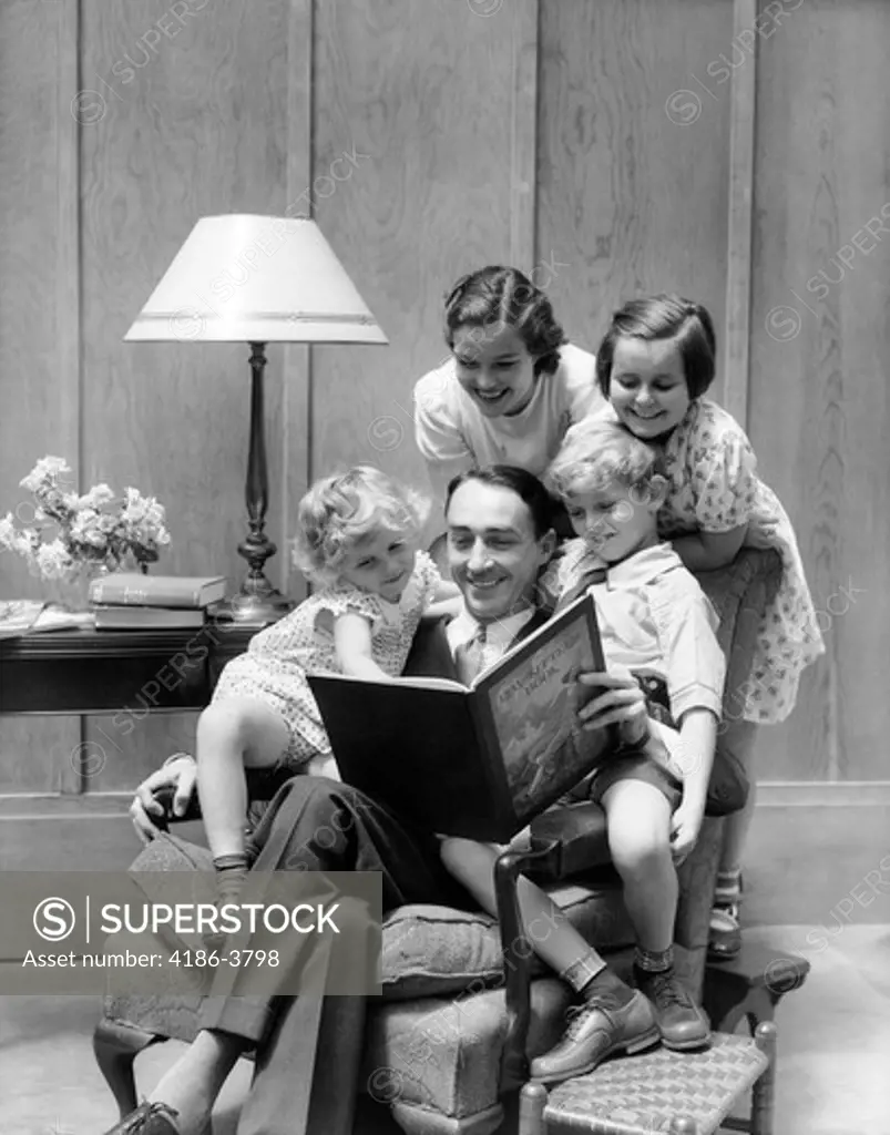 1930S Father Reading To Family In Chair