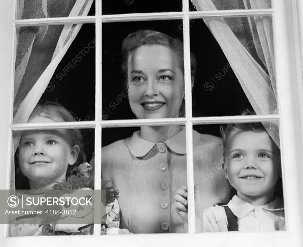 1950S Mom With Two Kids Looking Out Window Towards Viewer