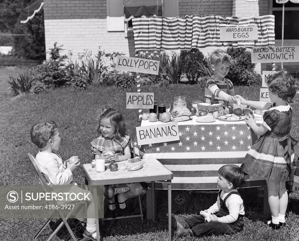 1950S Kids In Backyard Playing Store With Signs Selling Apples Bananas Sandwiches Lollypops
