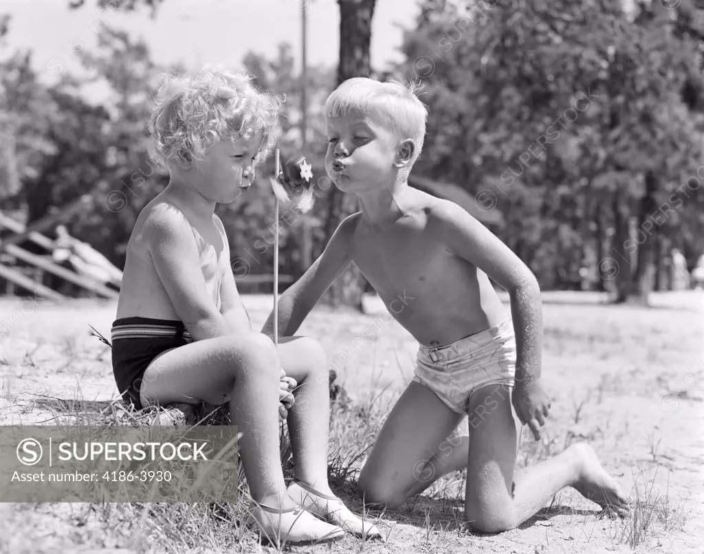 1940S Blonde Boy Girl Wearing Bathing Suits Blowing On A Pinwheel Toy Summer
