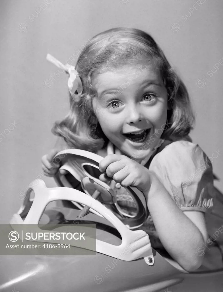 1950S Portrait Of Little Girl Driving Toy Car With Excited Expression Looking At Camera