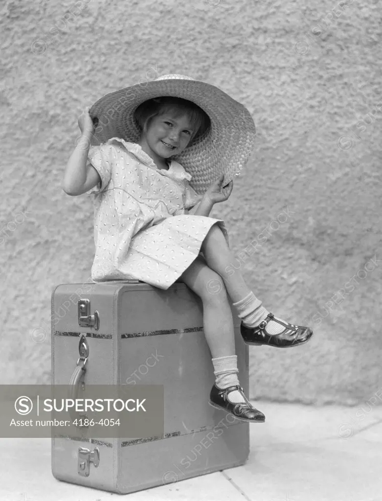1930S Portrait Smiling Little Girl Sitting On Suitcase Wearing Big Straw Hat