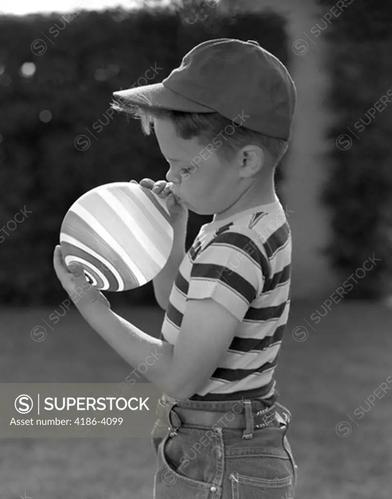 1950S Profile Of Boy In Baseball Cap & Striped T-Shirt Blowing Up Striped Balloon