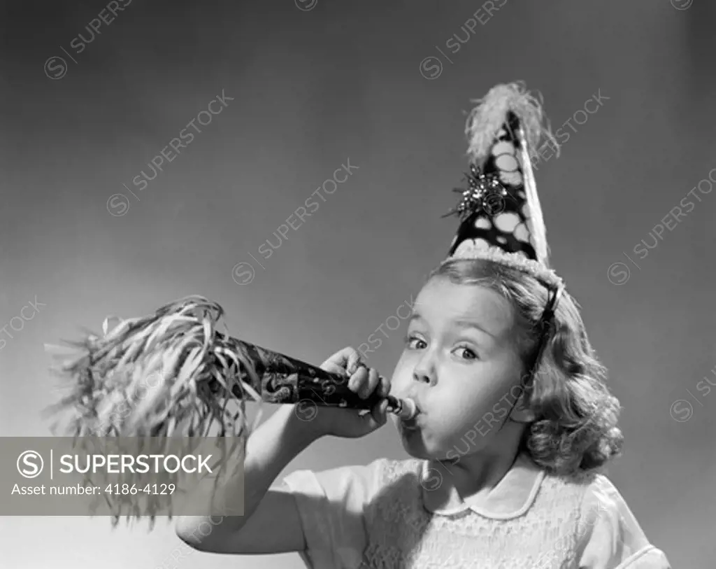 1950S Girl Wearing Party Hat Blowing Into Noise Maker Looking At Camera