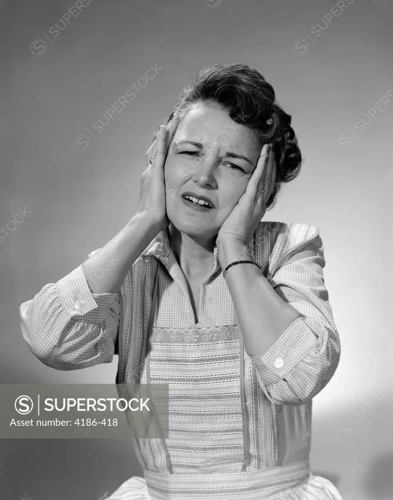 1950S Woman In Cotton Dress With Both Hands Over Her Ears Holding Her Frowning Head