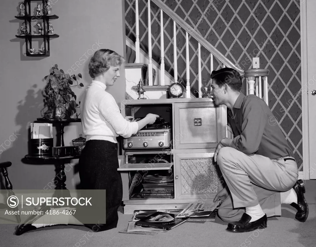 1950S Teenage Couple Playing Hi-Fi Records On Console Phonograph In Living Room