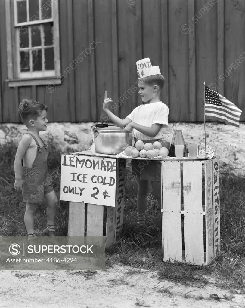 1940S Boy Running Lemonade Stand On Orange Crates Selling To Little Boy