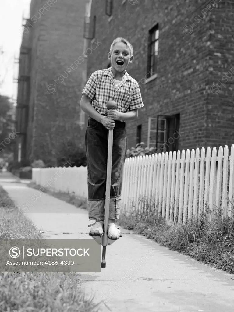 1960S Boy On Pogo Stick On Sidewalk
