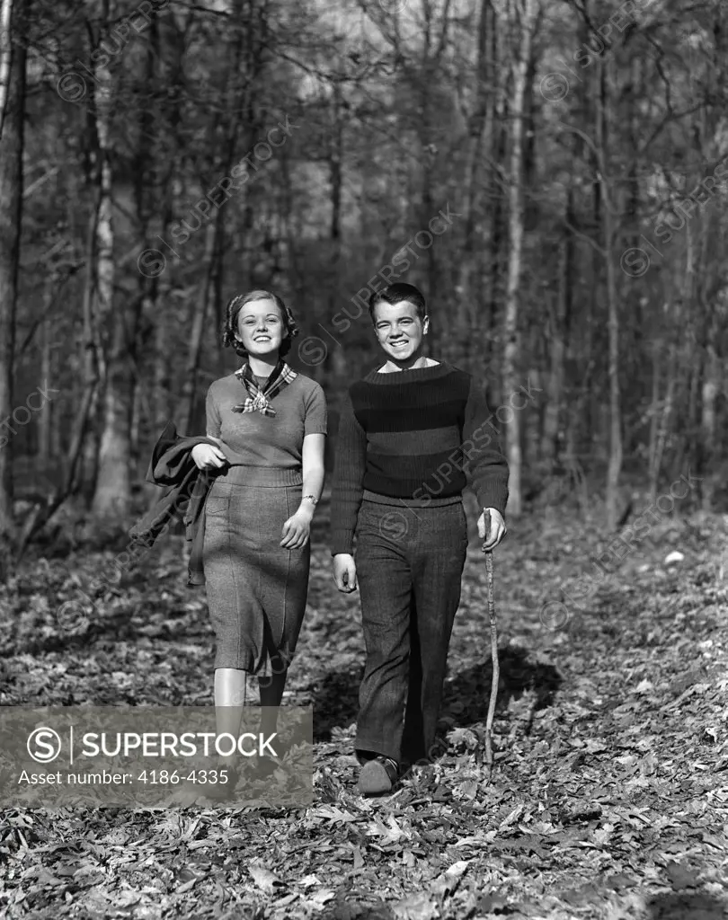 1940S Teen Couple Boy Girl Walking In Autumn Woods Landscape