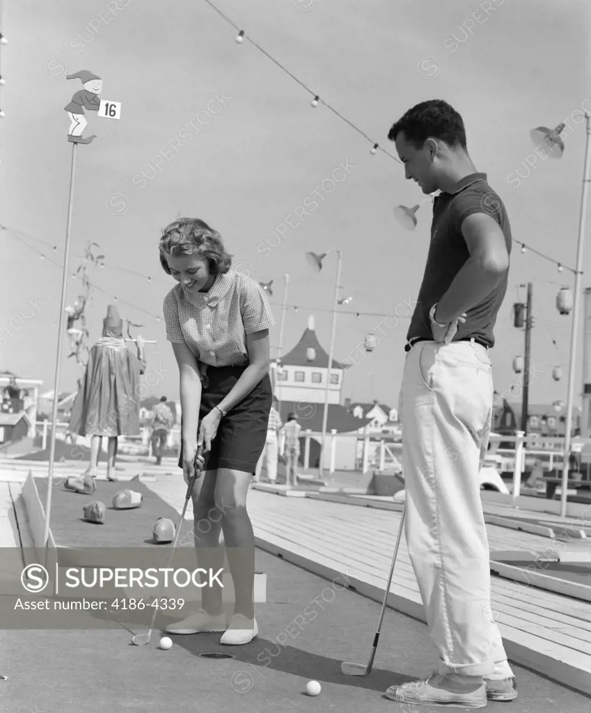 1960S Teenage Couple Playing Miniature Golf