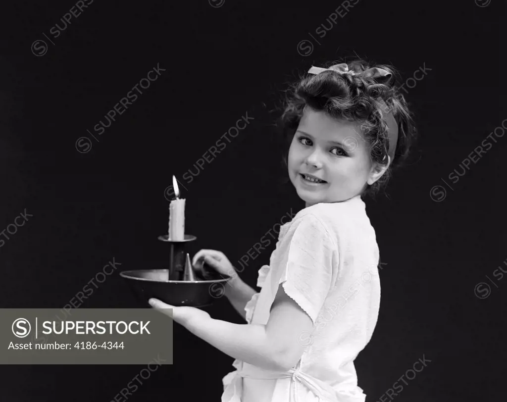 1940S Child Little Girl Holding Candle Looking At Camera