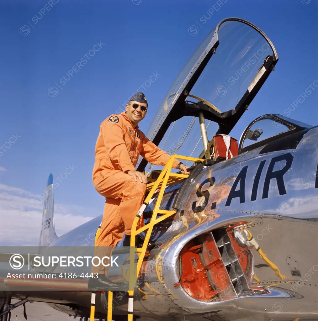 1970S Smiling Military Pilot Ladder Climbing Enter Cockpit Jet Wearing Orange Flight Jump Suit Pilots Men