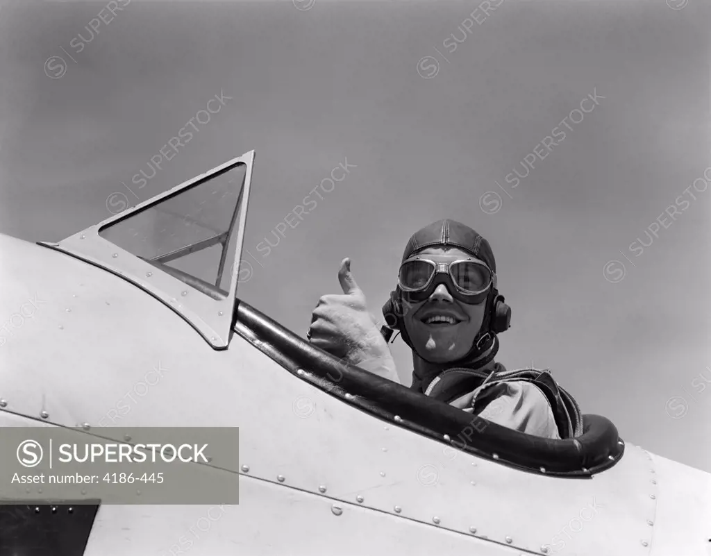 1940S Smiling Army Air Corps Pilot In Open Cockpit Wearing A Leather Flying Helmet Giving A Thumbs-Up Sign