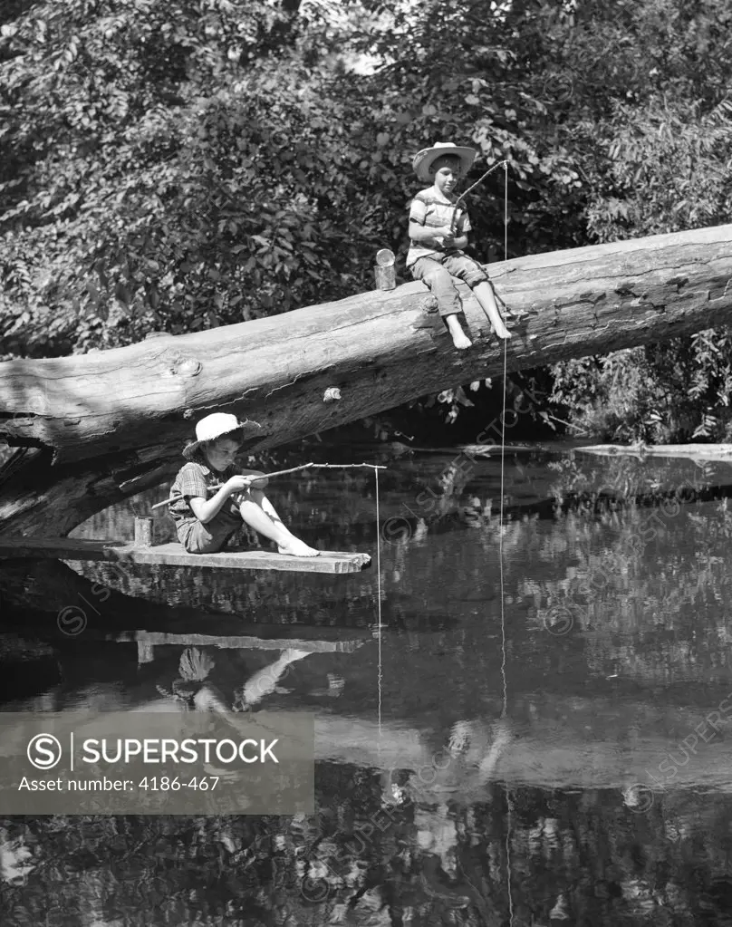 1940S 1950S Pair Of Boys In Straw Hats & Cuffed Jeans Fishing In Stream Off Of Fallen Tree & Diving Board With Stick & String Poles