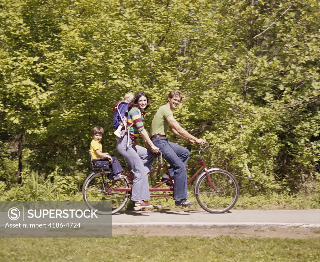 1970S Family On Tandem Bicycle Mother Father Son Back Seat Baby Daughter Backpack Wearing Bellbottom Blue Jeans