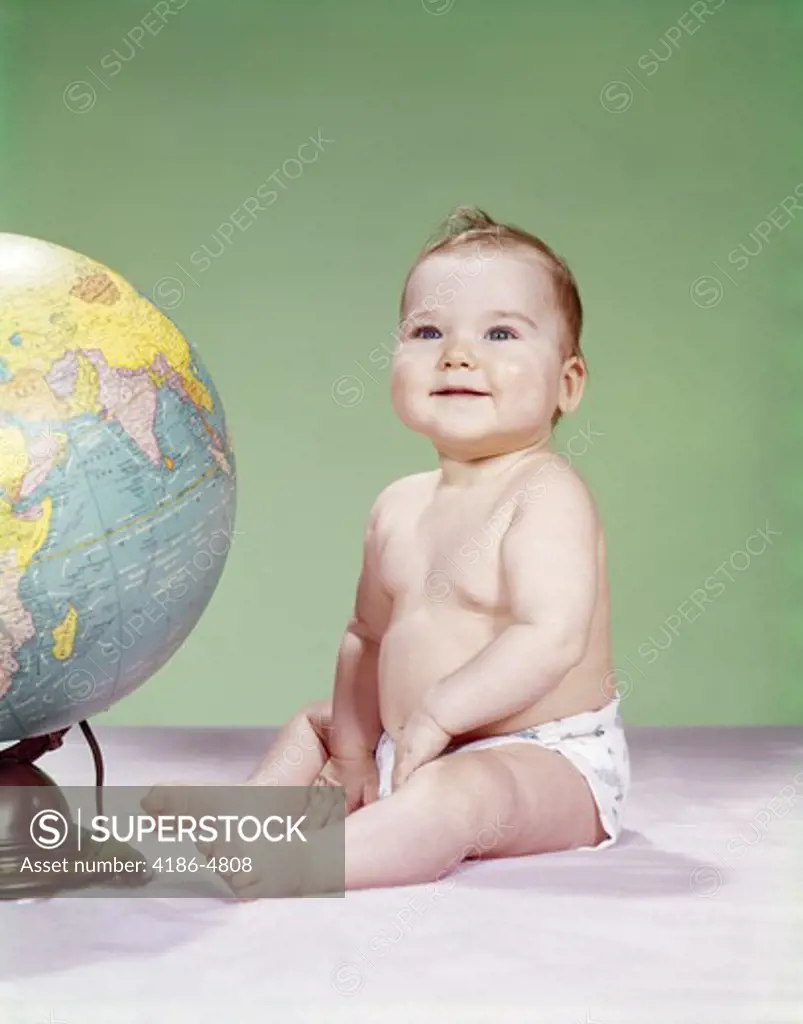 1960S Smiling Baby Wearing Diaper Sitting Beside Earth Globe