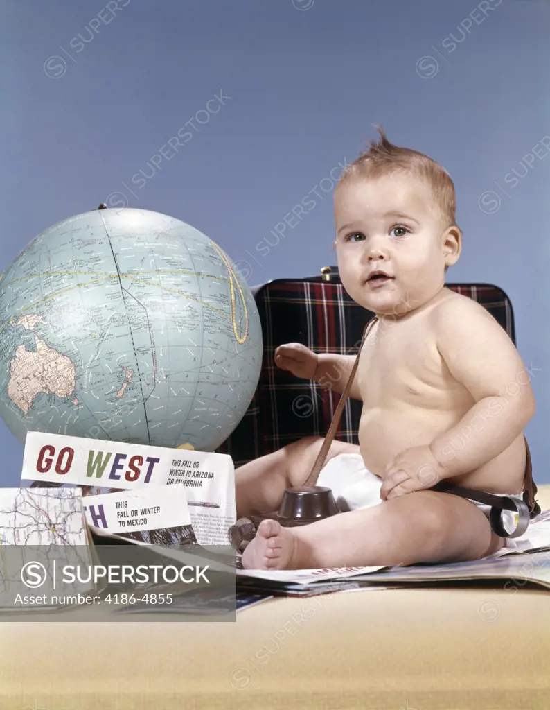 1960S Baby Boy Sitting By World Globe With Suitcase And Travel Paraphernalia Looking At Camera