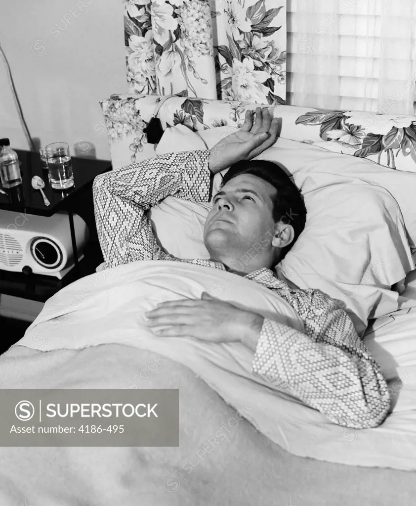 1940S 1950S Sick Man In Bed In Pajamas One Hand On Chest One Above His Head On Pillow