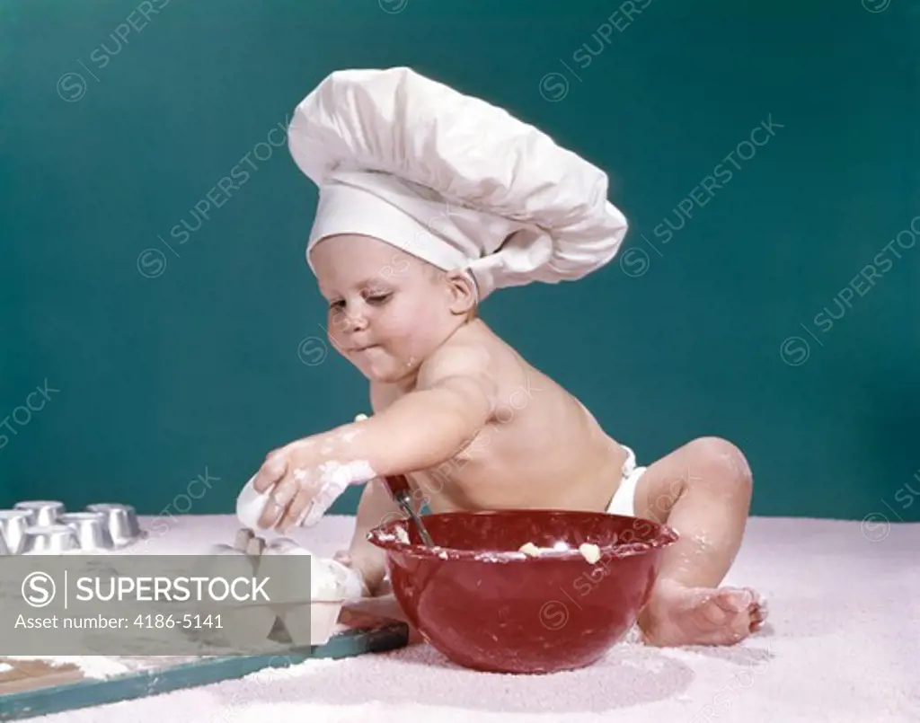 1960S Baby Wearing Chefs Hat Holding Egg Surrounded By Cooking Equipment