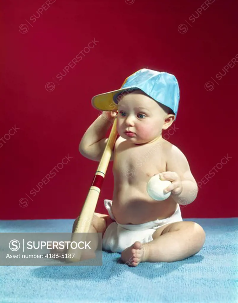 1960S Baby Wearing Blue Baseball Cap Holding Ball And Bat