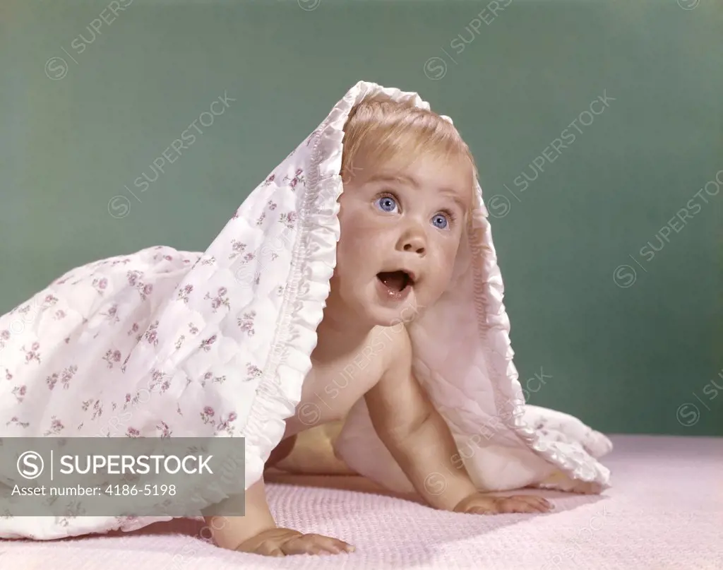 1960S Baby Crawling And Peeking Out From Under A Blanket