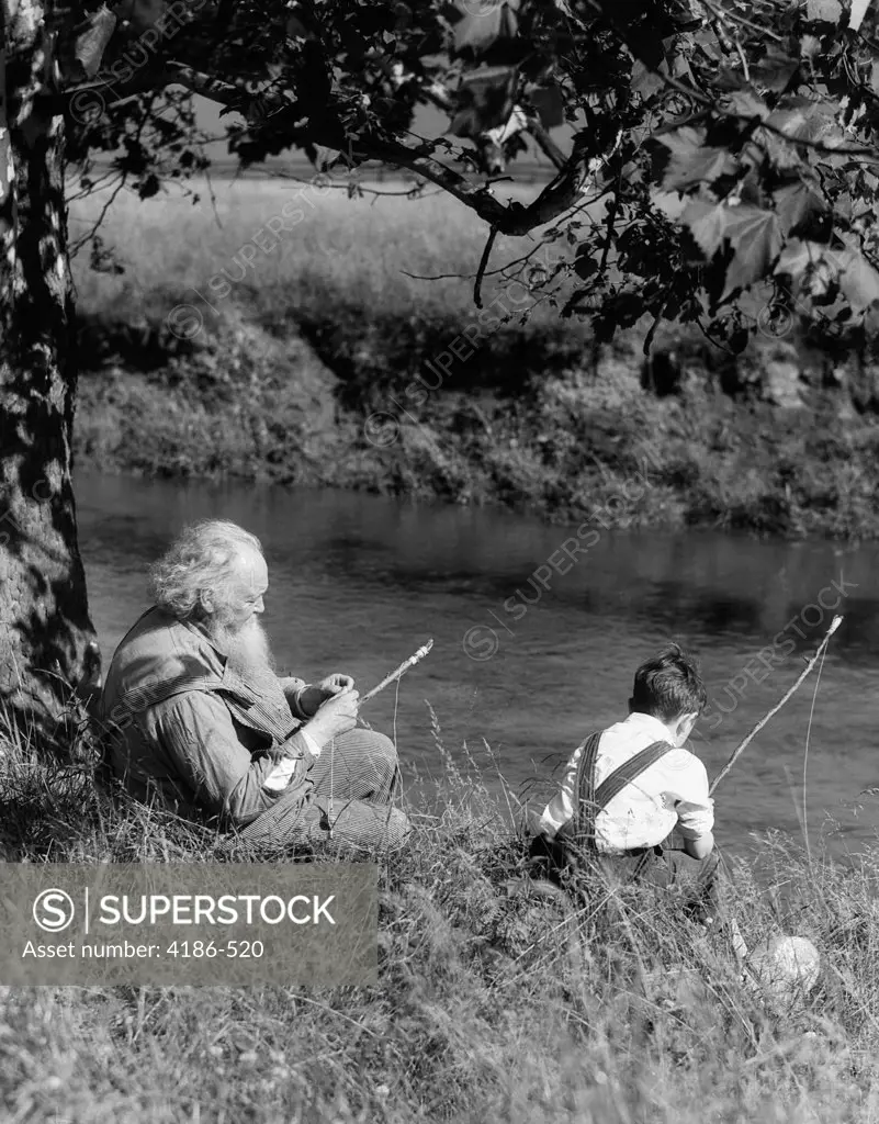 1930S Boy & Grandfather Fishing On Bank Of Stream