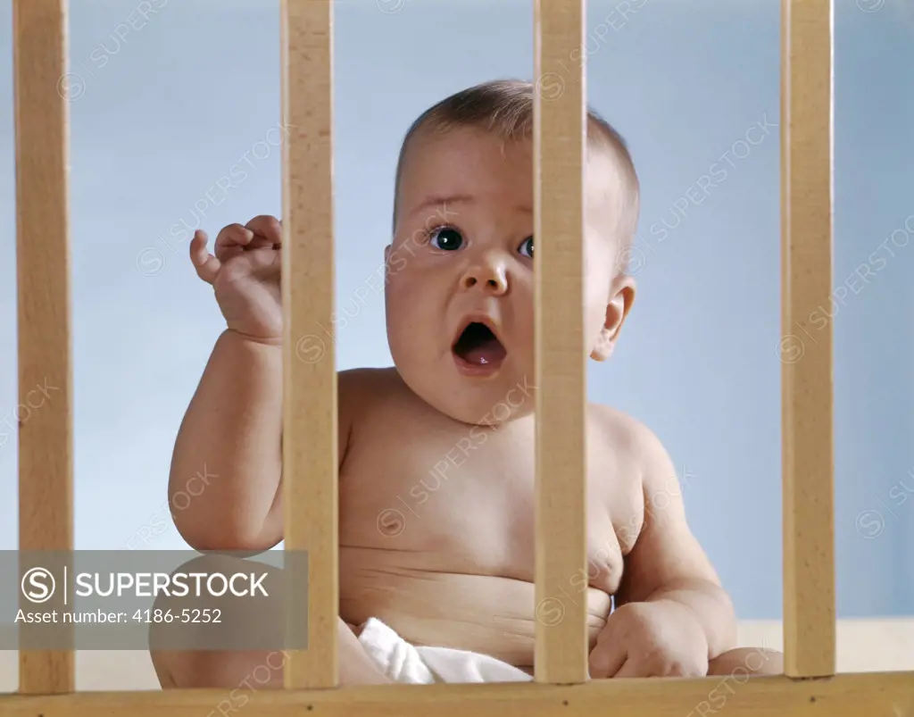 1960S Baby In Crib Or Playpen Looking Through Bars Alarmed Expression