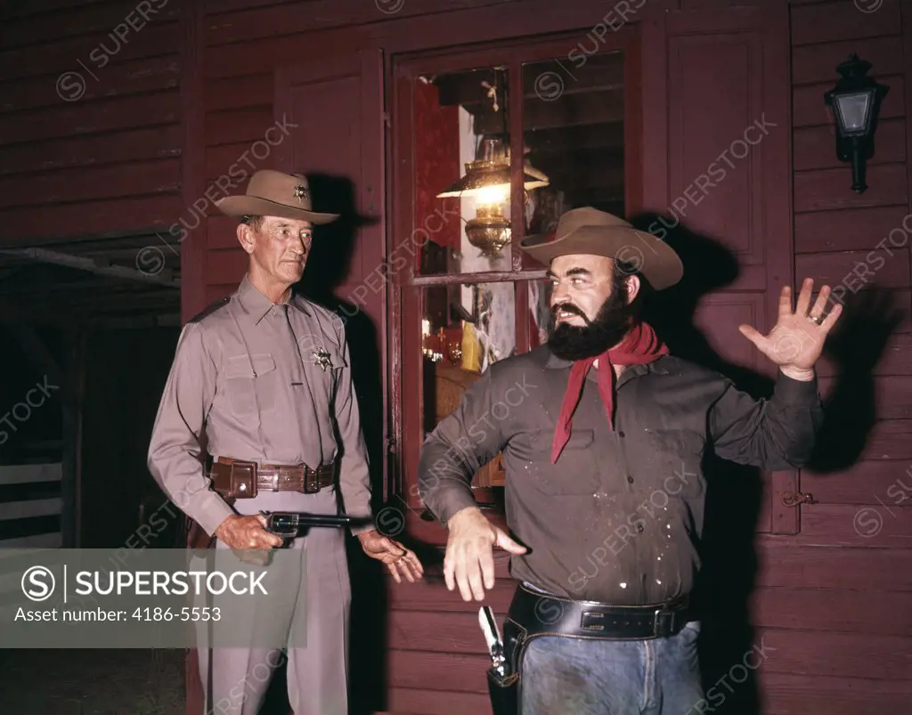 1960S 1970S Western Sheriff Arrests Bearded Cowboy About To Draw Gun