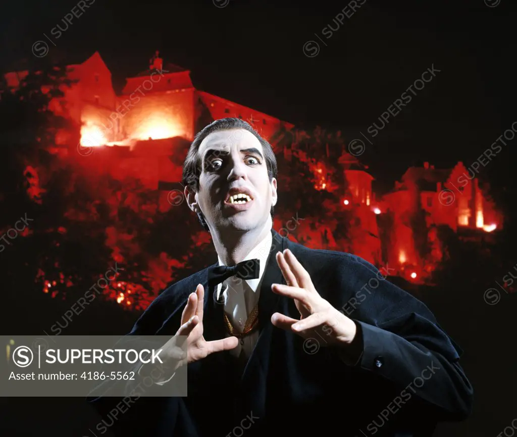 Man In Vampire Makeup And Costume Gesturing Menacingly Castle Background Studio Superstition Folklore