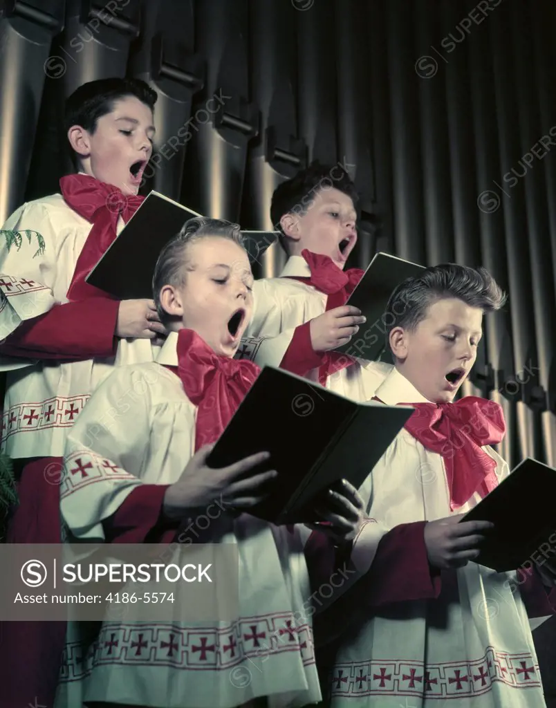 1950S Four Choir Boys In Red And White Robes Singing In Front Of Church Organ Pipes