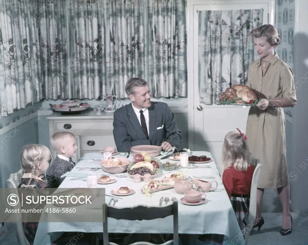 1950S Happy Family 5 Dining Room Table Mom Bring Turkey On Platter Dad Kids Sit Interior Curtains Meal Boy Girl