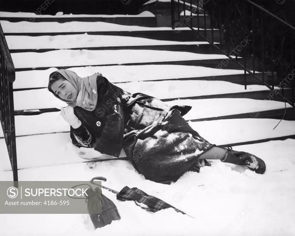 1950S Woman Lying On Snow Covered Steps Fall Accident Slip Expression Of Pain