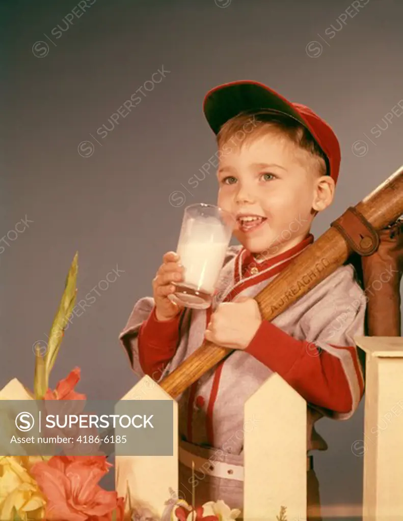 1950S 1960S Boy Drinking Milk Wearing Baseball Uniform  By Picket Fence