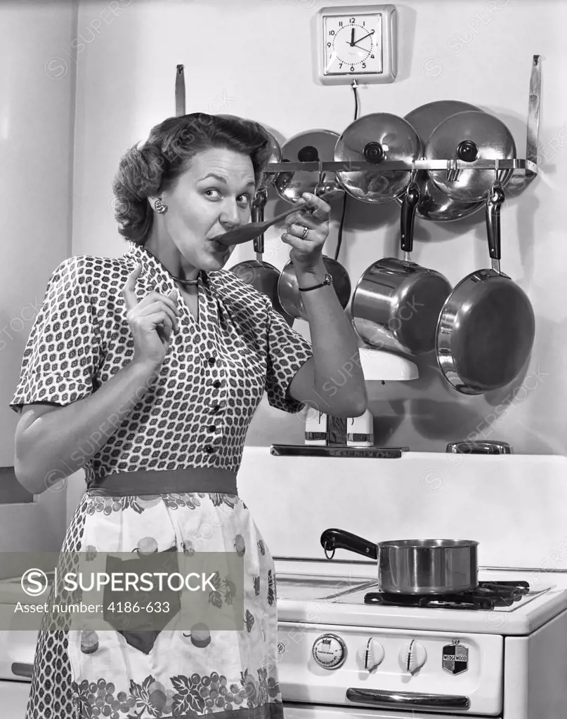 1950S Housewife Tasting With Spoon By Stove Funny Facial Expression