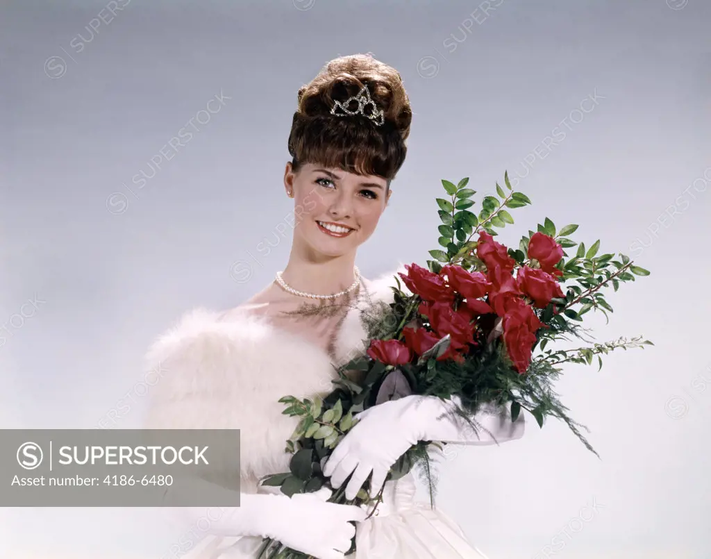 1960S Woman Prom Queen Wearing White Evening Dress Holding Bouquet Of Flowers Red Roses  