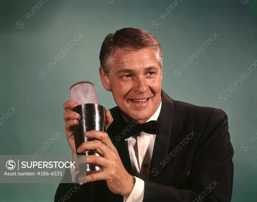 1960S 1970S Bartender Smiling Man In Black Tuxedo Mixing Cocktail In Shaker