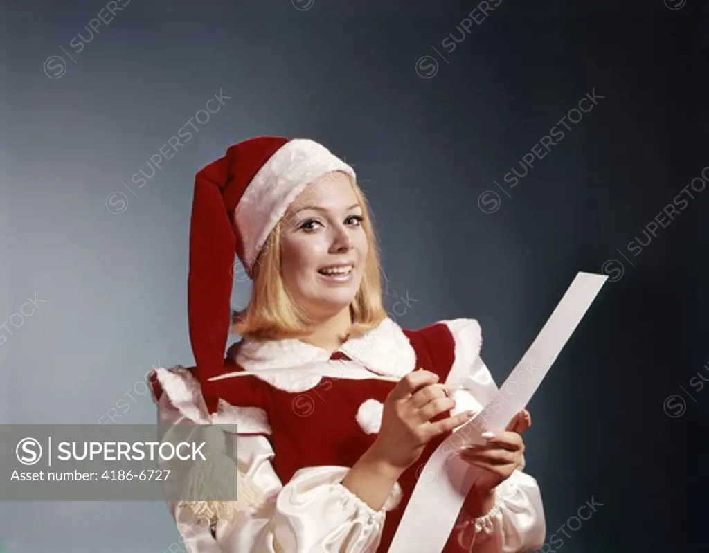 1960S Young Woman In Santa Helper Hat And Costume Holding Pen And List Symbolic Portrait