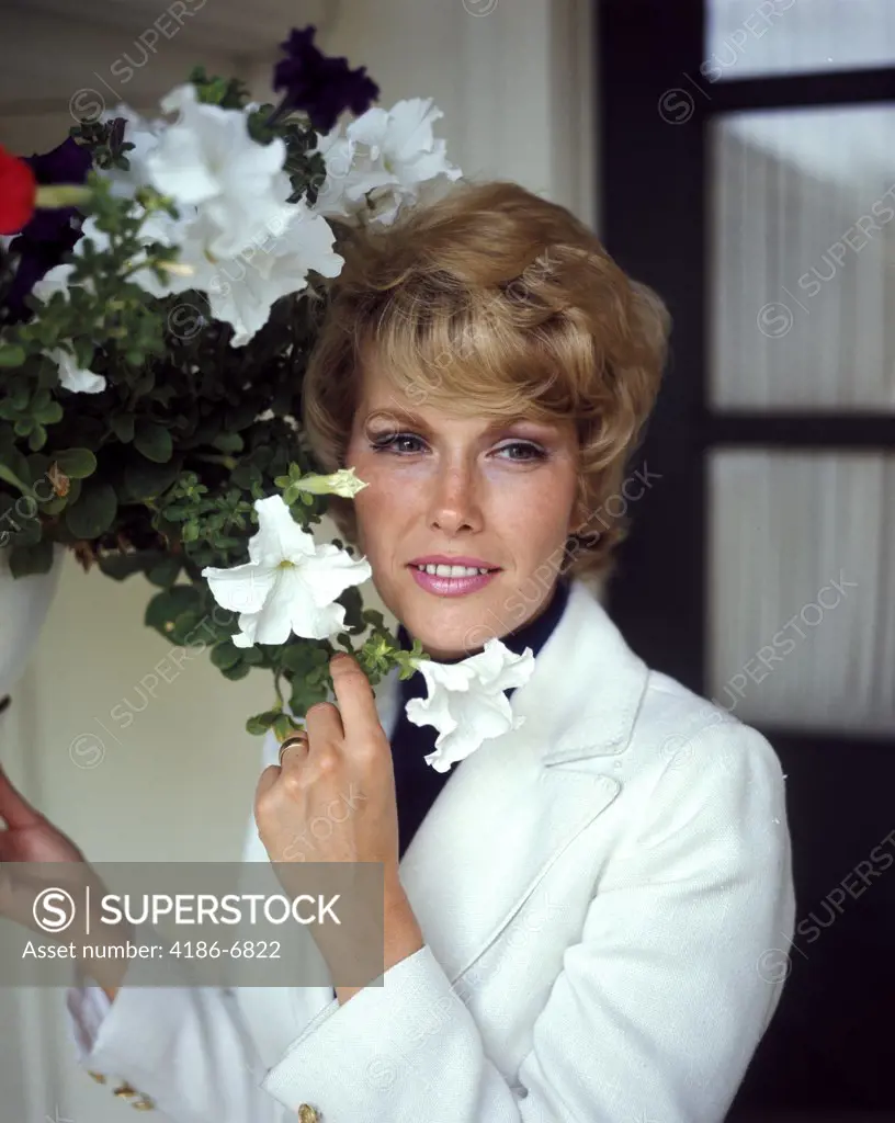 1970S Smiling Blond Woman White Jacket Hanging Basket Of Petunias Portrait Flowers