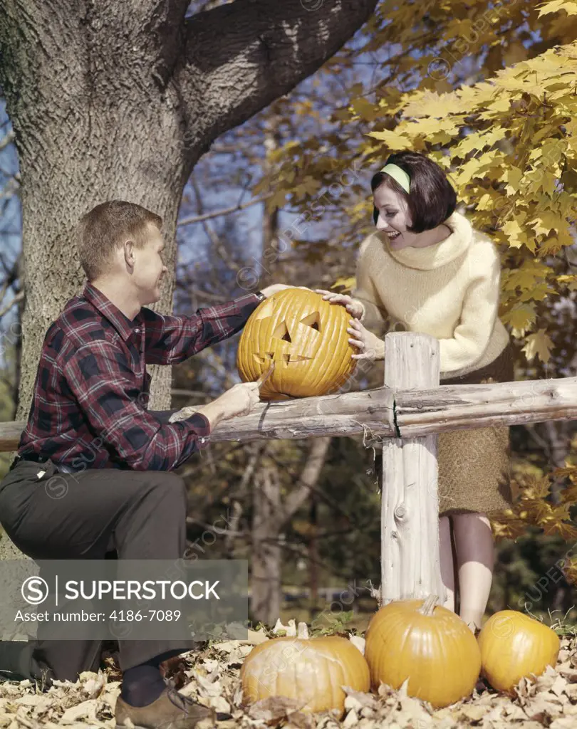 1960S Young Couple Man Woman In Autumn Woods Carving Halloween Jack-O-Lantern Pumpkin