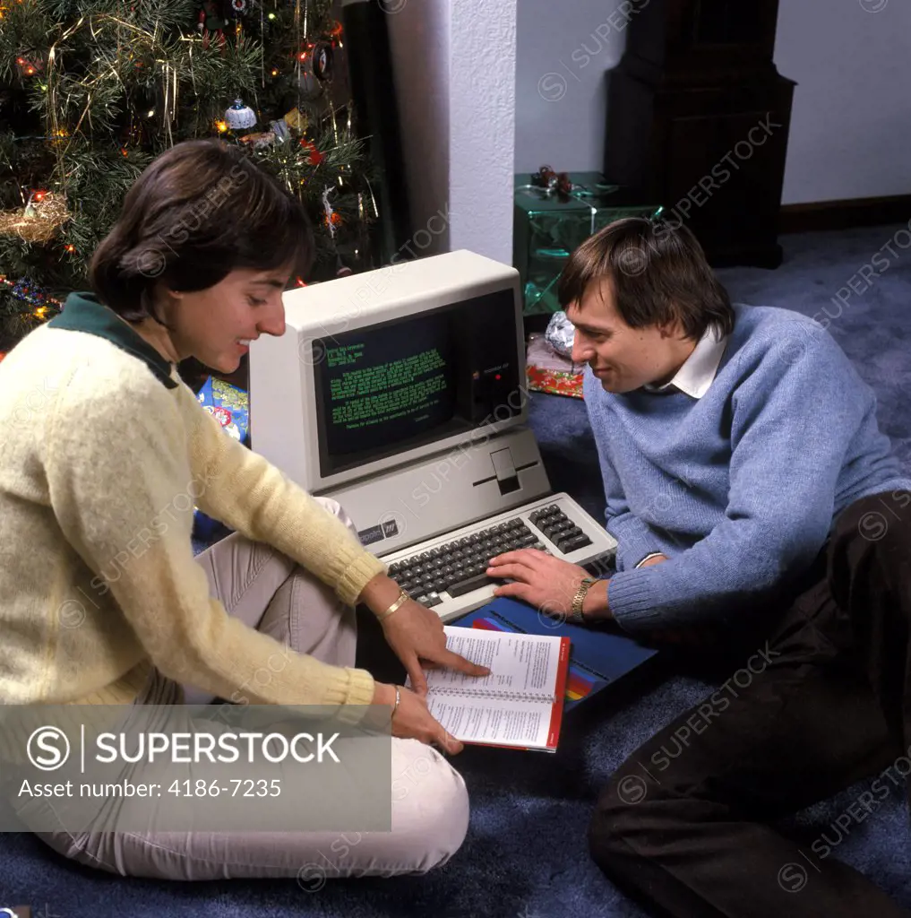 1980S Couple By Christmas Tree Reading Instructions For An Apple Iii Computer  