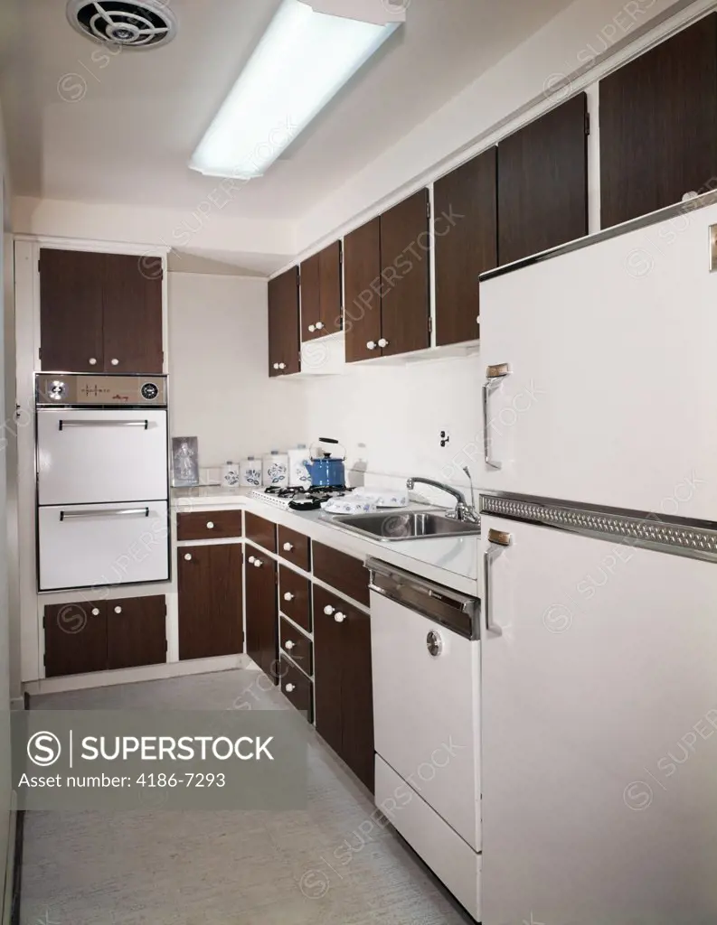 1970S Narrow Galley Style Kitchen With Dark Wooden Cabinets And White Appliances