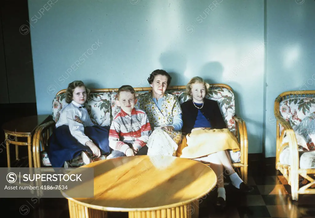 1950S Mother And Children Sitting On A Rattan Sofa