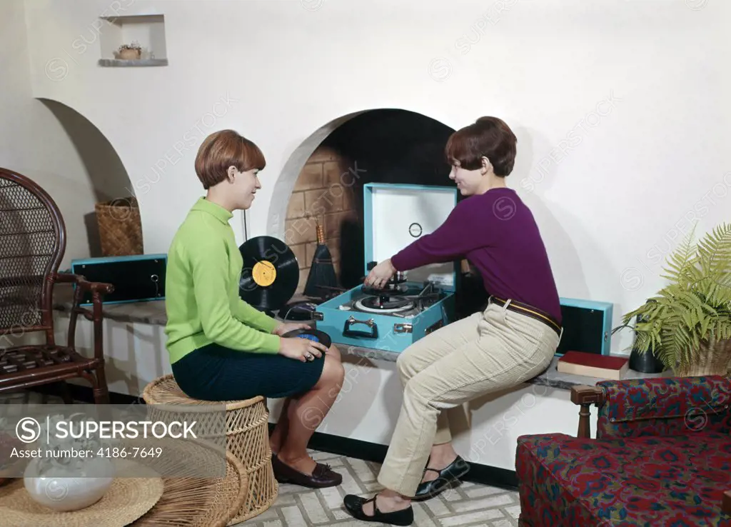 1960S Two Teenaged Girls Playing Records On Player In Wall Niche In Living Room
